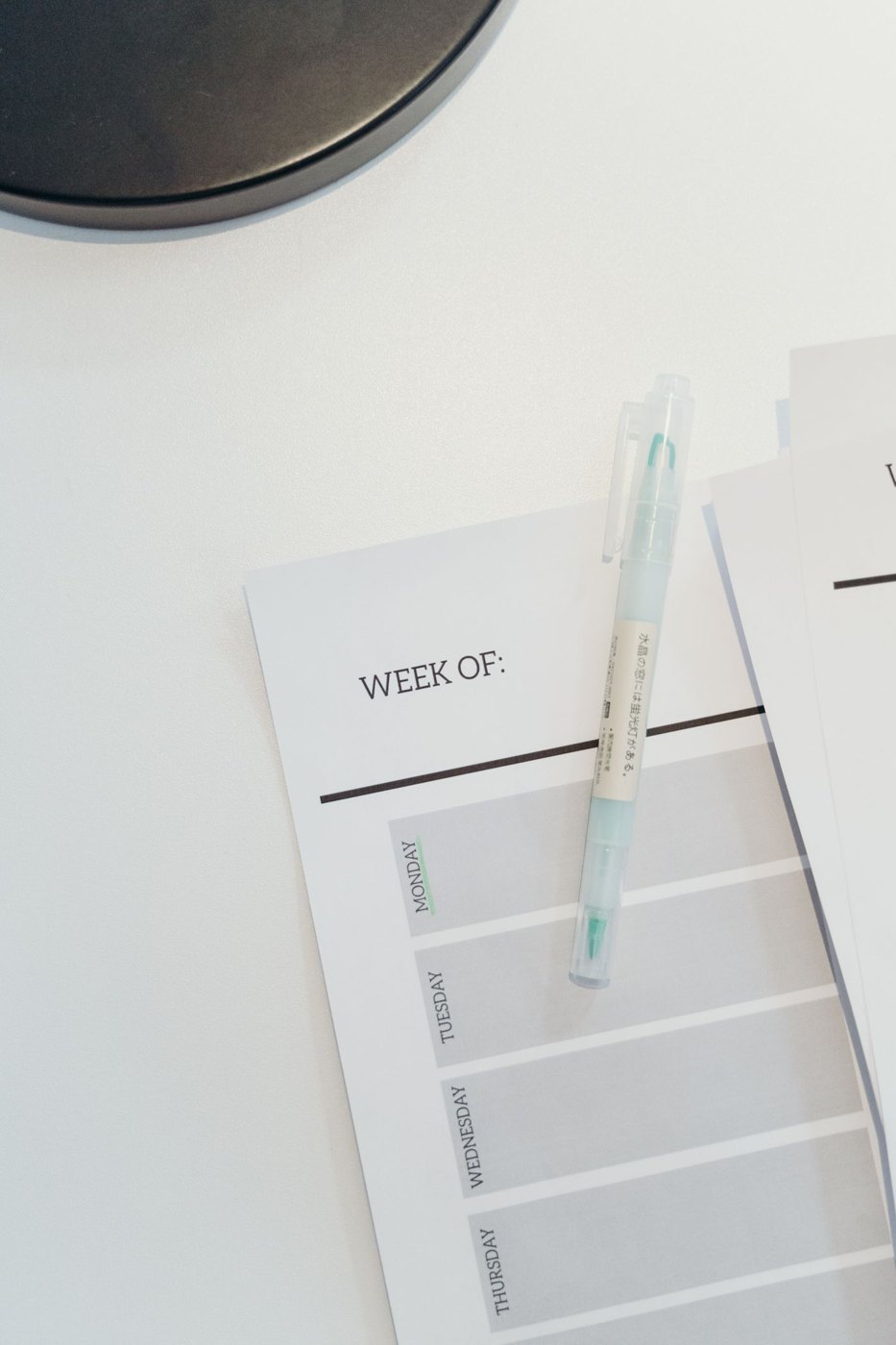 An open weekly planner with a pen
