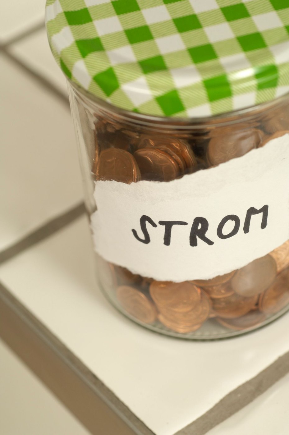 A labelled jar holding coins for an electricity expense