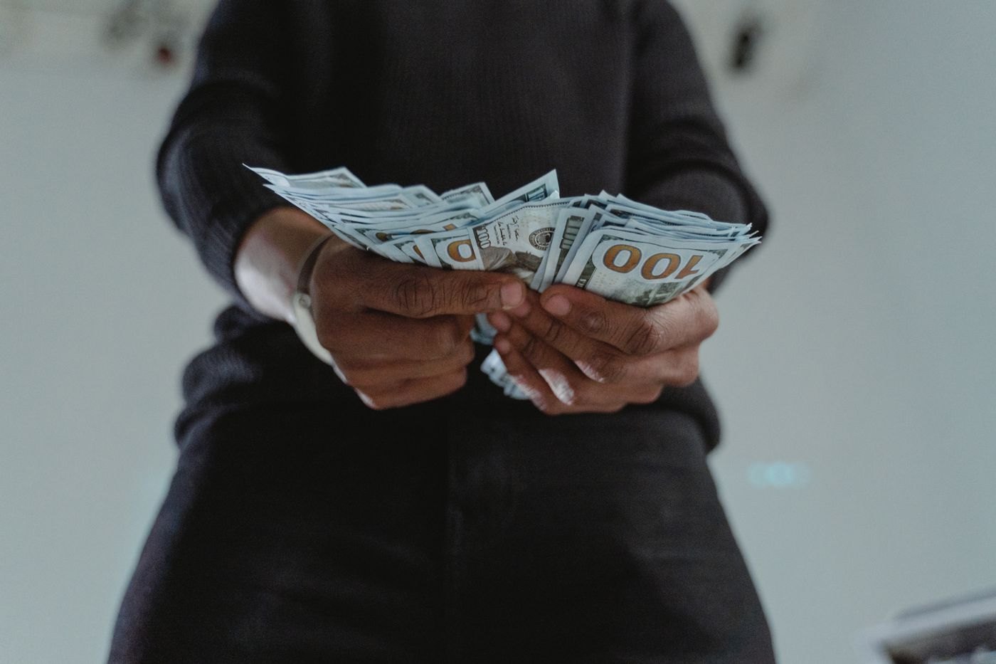 Hands counting a small group of banknotes