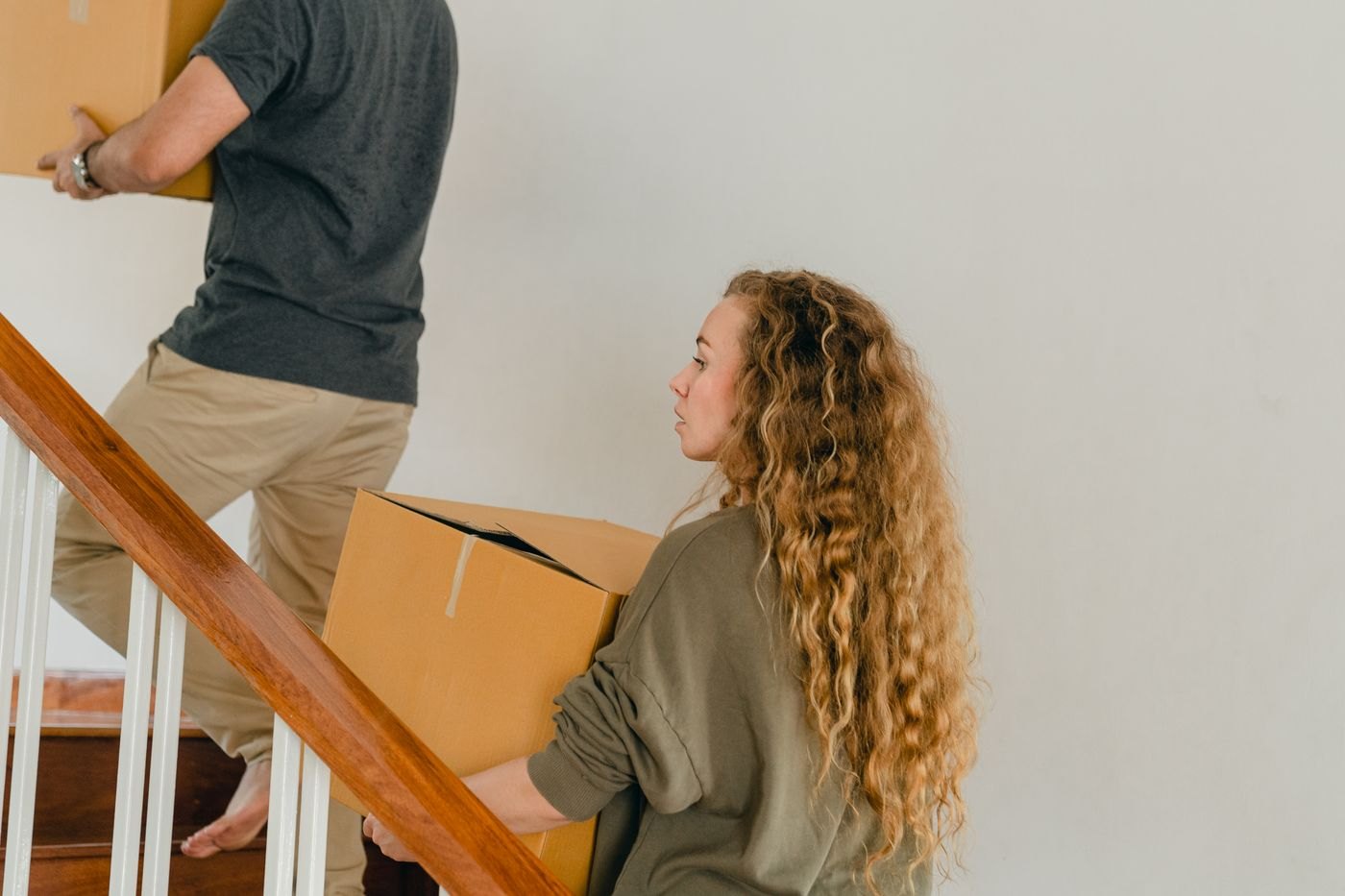 A couple moving cardboard boxes into a home