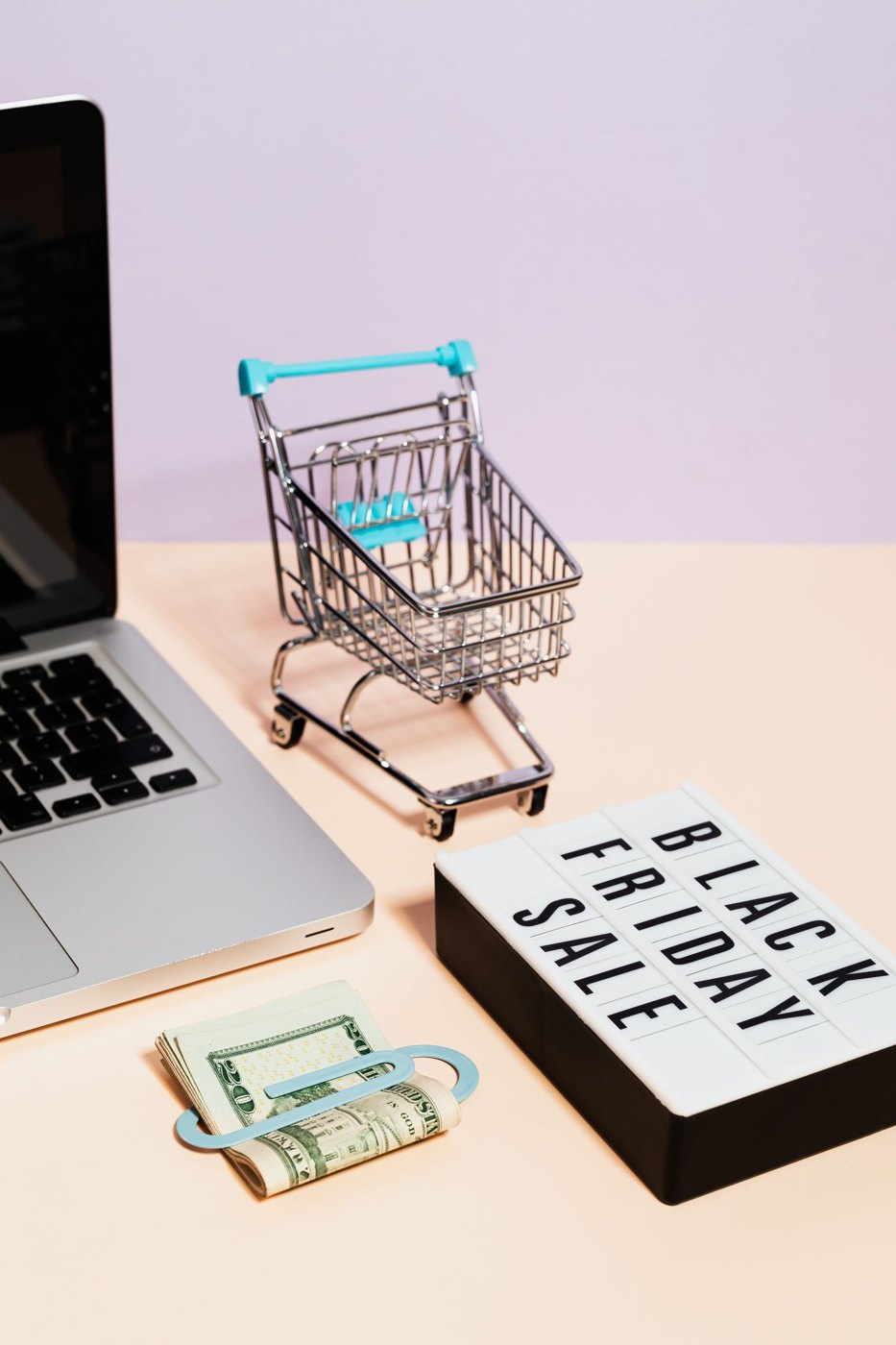 A seasonal sale sign beside a shopping cart and cash