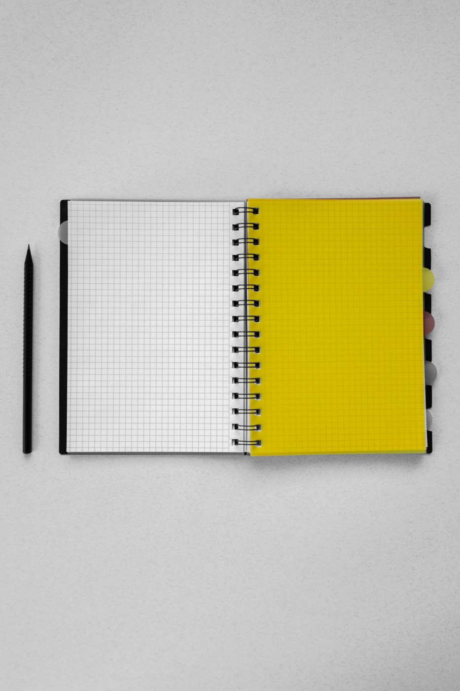 Graph-paper notebook open beside a pencil
