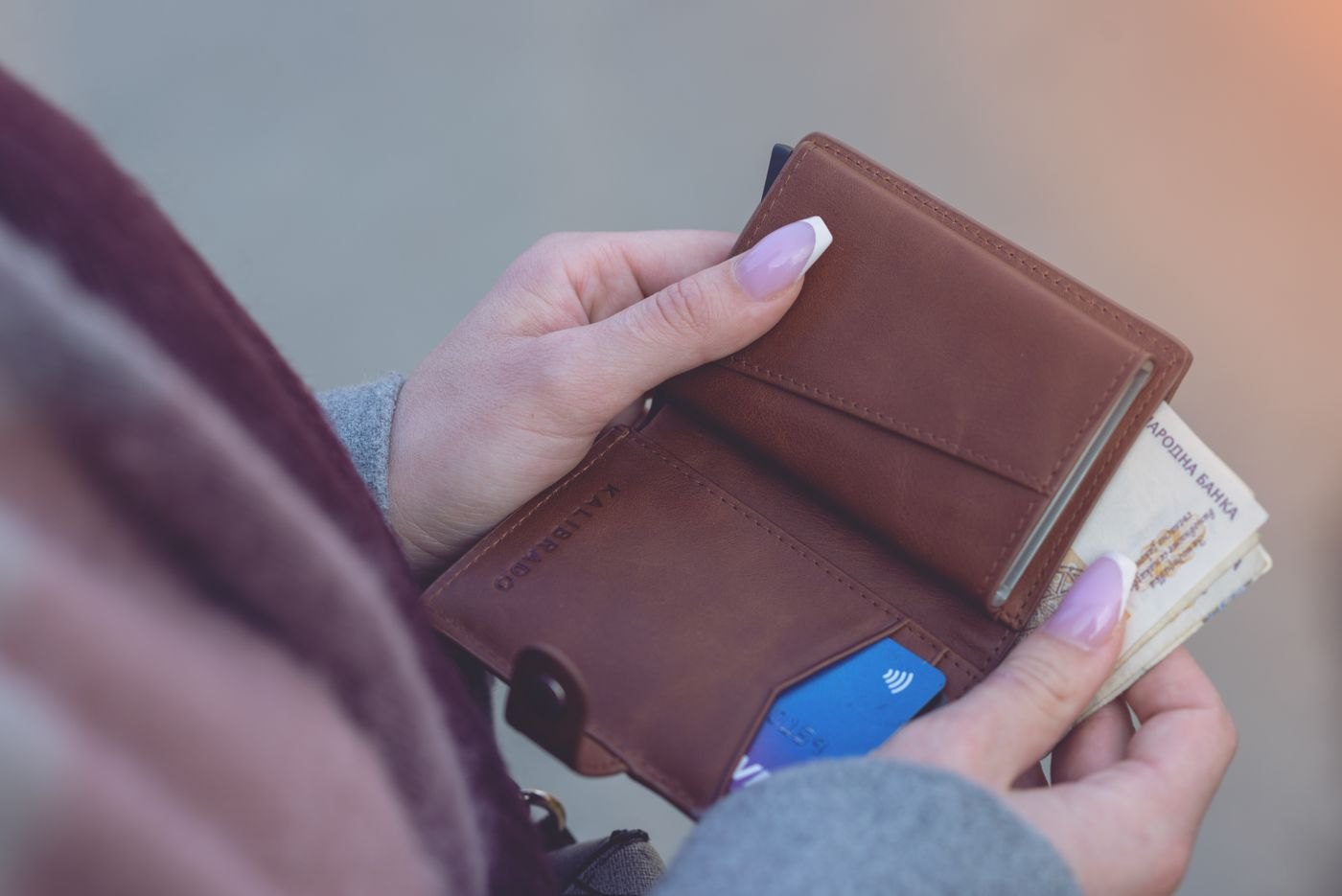 A person checking the contents of a wallet