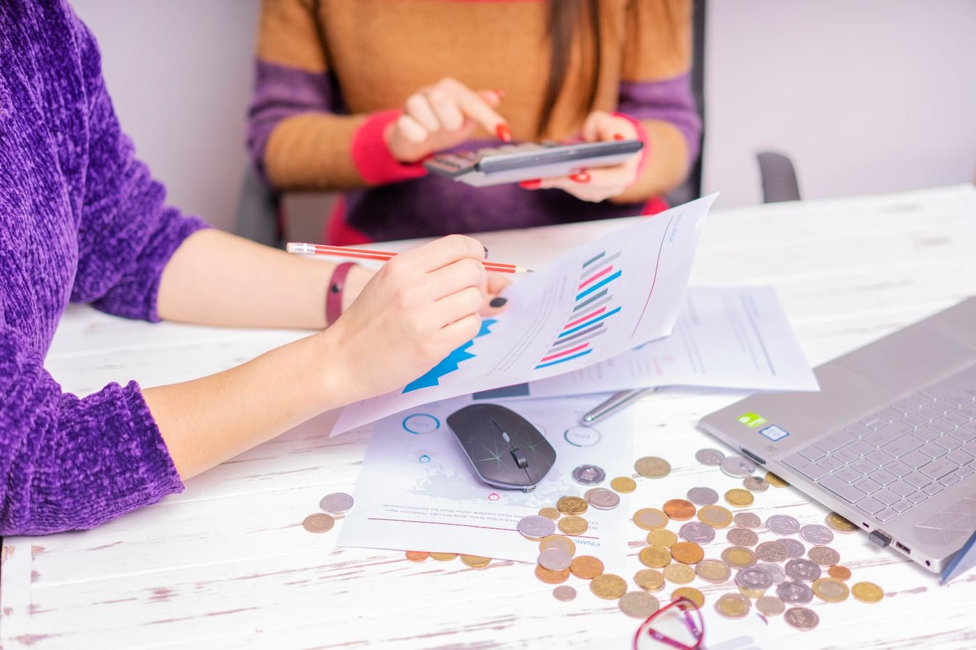 Two people reviewing money and financial charts