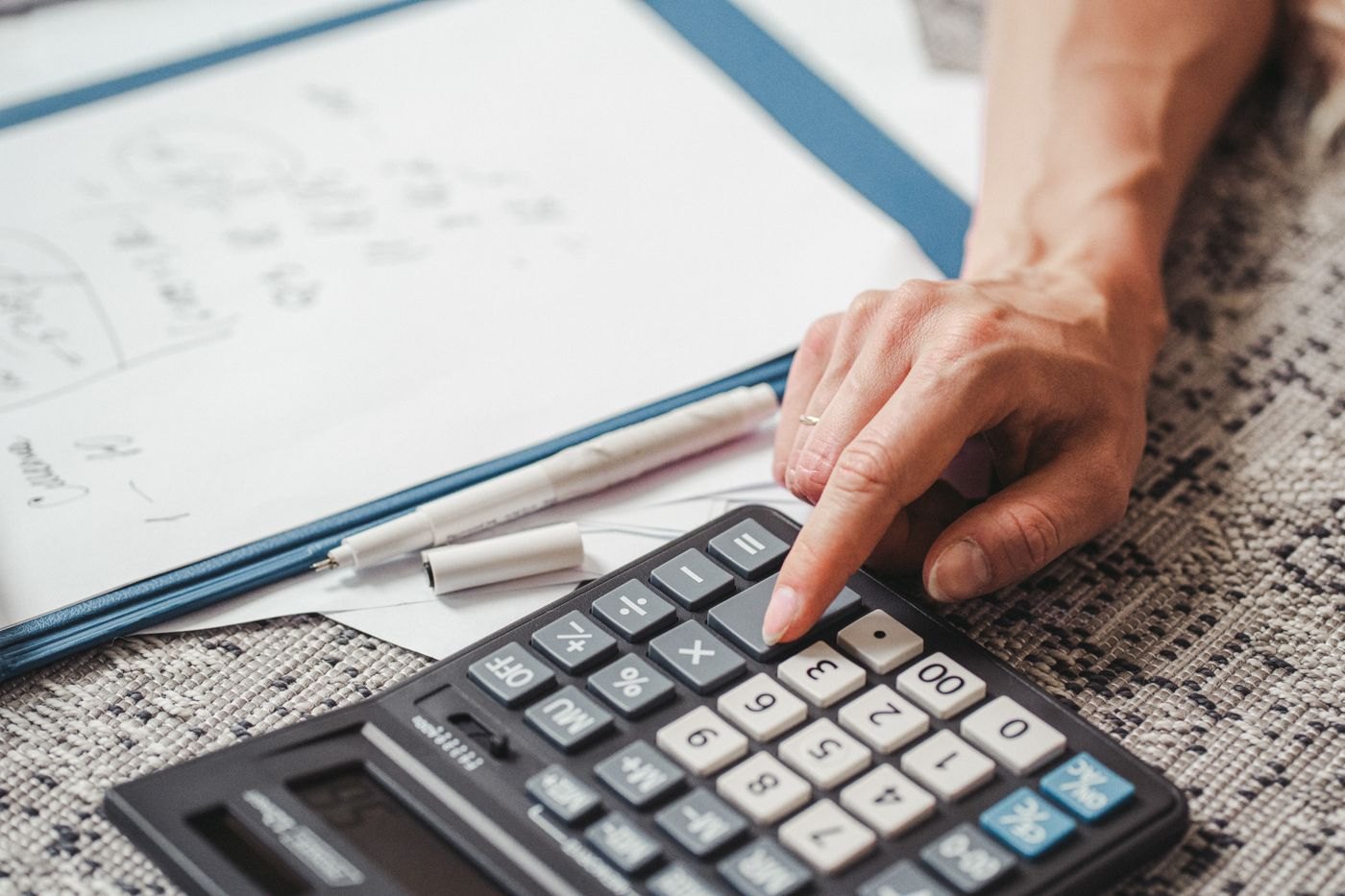 A calculator being used over paperwork