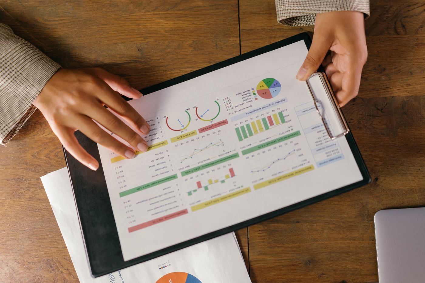 A clipboard holding printed charts and graphs