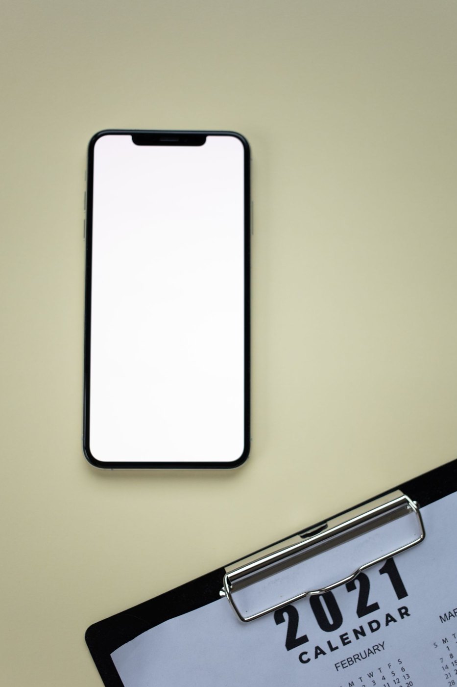 A smartphone beside a paper calendar