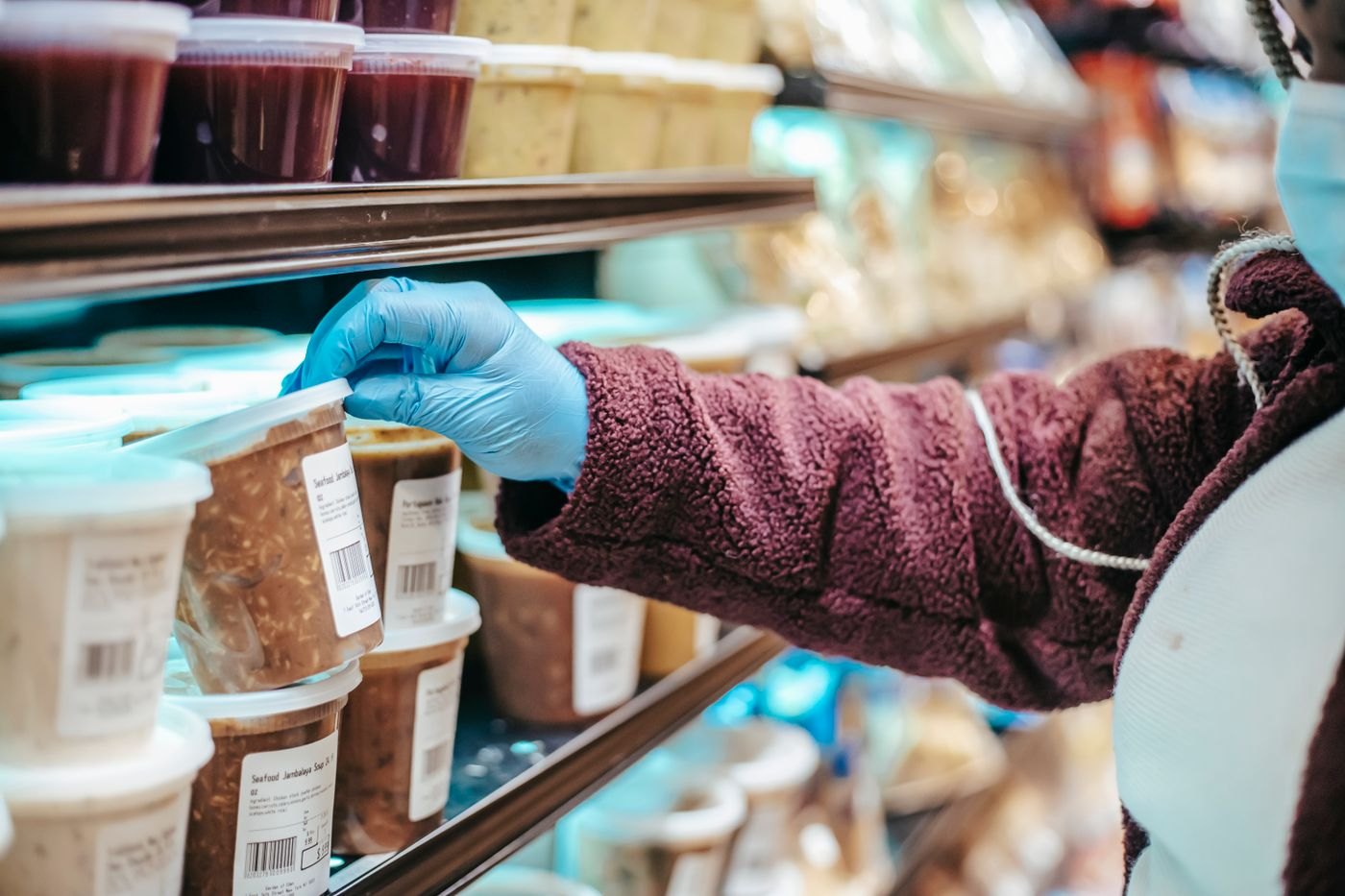 A shopper reading the label on a supermarket product