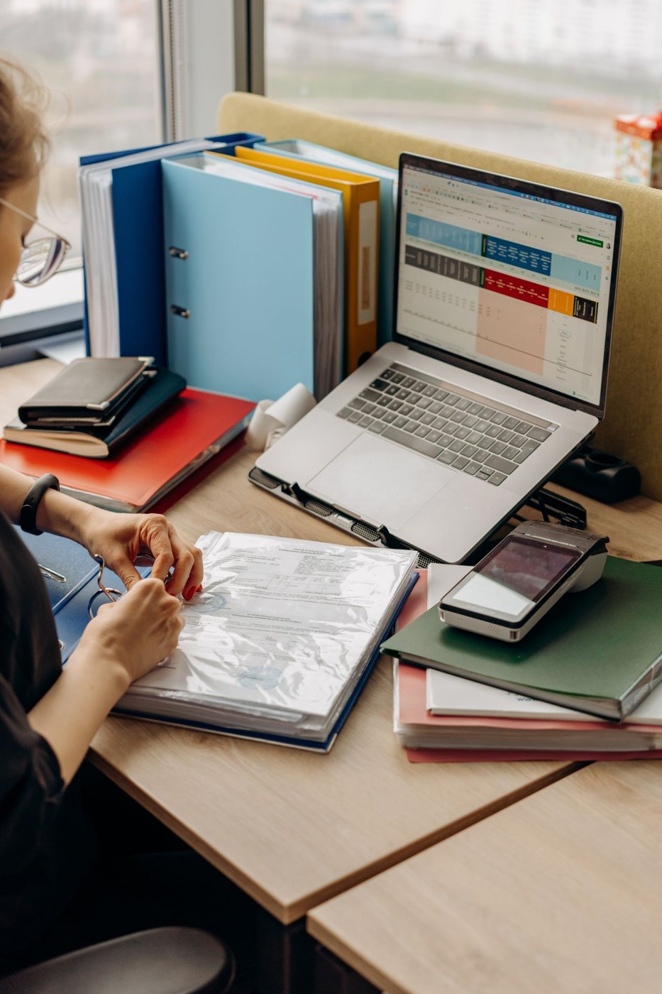 A person organising a binder of documents